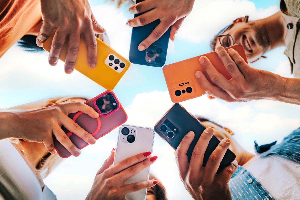 people holding their phones, view from underneath the phones in a circle