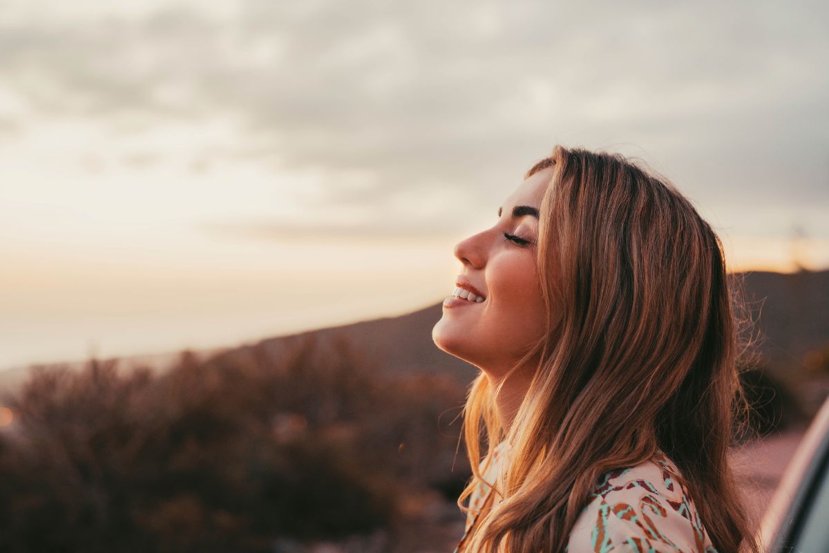 woman outside looking up smiling