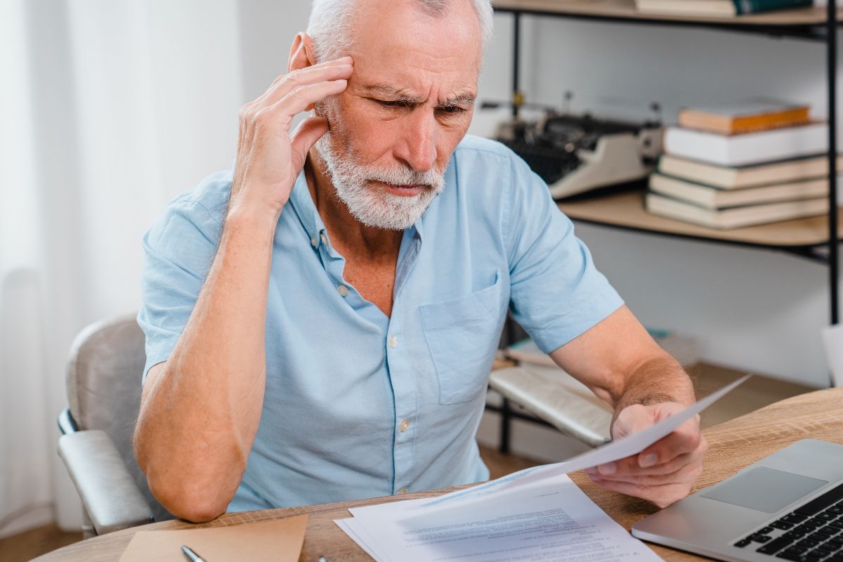 Man looking at paperwork looking serious.
