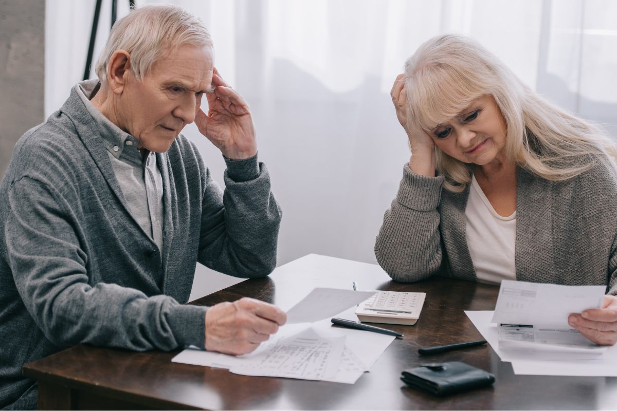 Retired couple looking stressed at bills