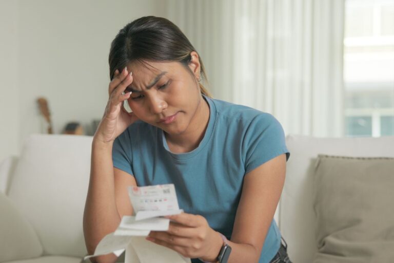 Woman looking stressed at bills