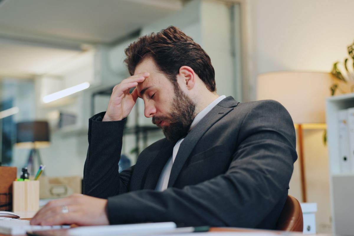 man tired at his office desk