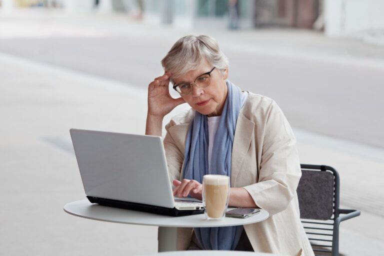 senior woman working on a lap top and looking stressed