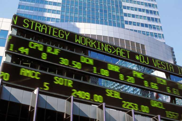 stock market board infront of a high rise building