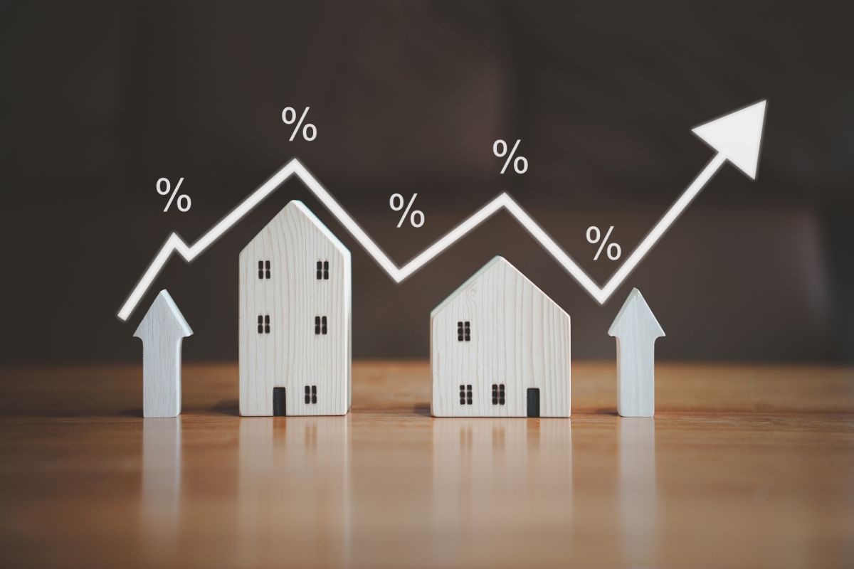 wooden house blocks with an arrow above indicating mortgage rates
