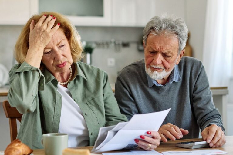 Older couple looking frustrated with bills