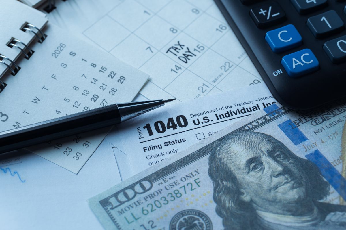 Tax forms, cash and a pen and calculator