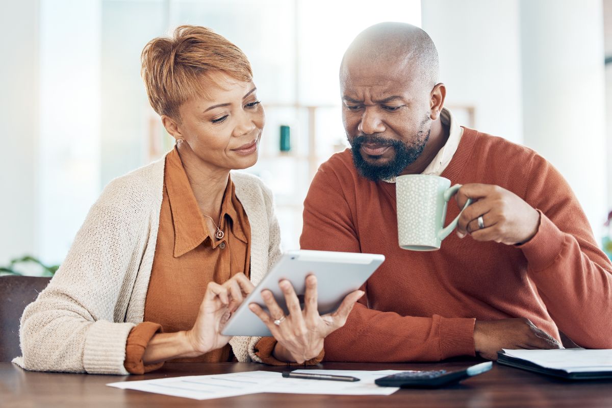couple drinking coffee looking at bills