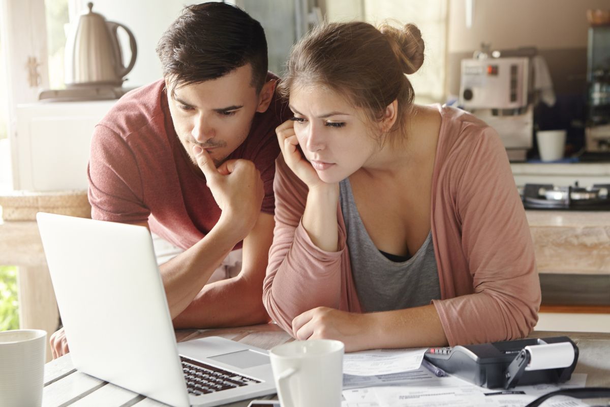 couple looking at the laptop with a calculator