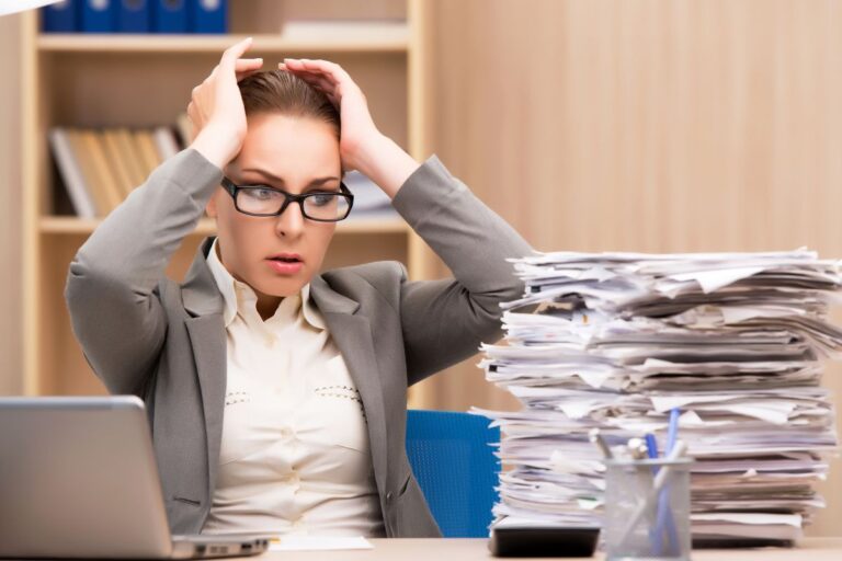 woman at work with a large stack of papers