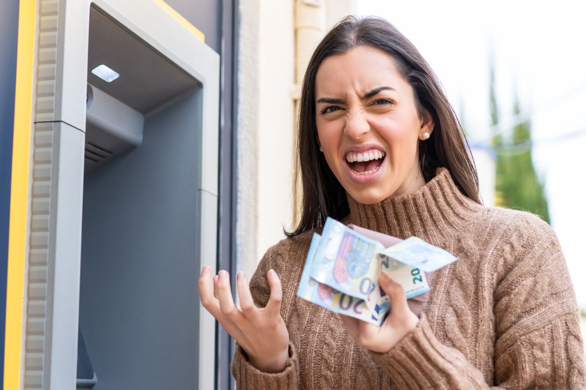 woman holding cash looking annoyed